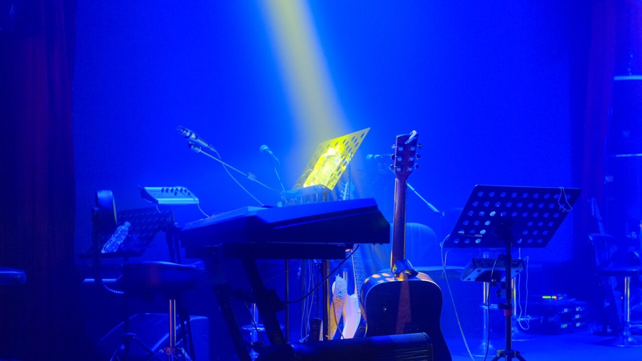 A stage with a piano, keyboard and other musical instruments