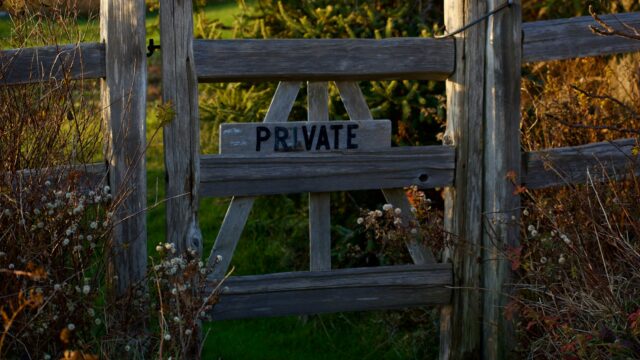 a wooden fence with a private sign on it